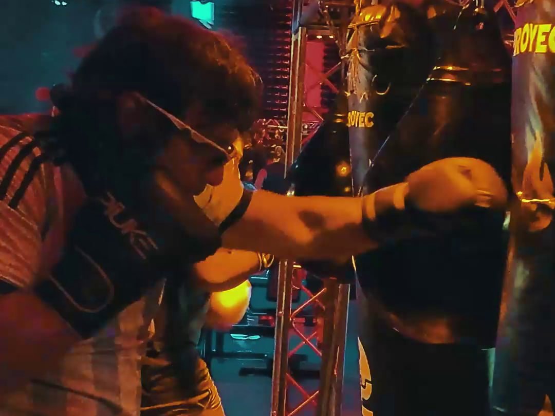 Alumno con casco golpeando la bolsa bajo luces rojas
