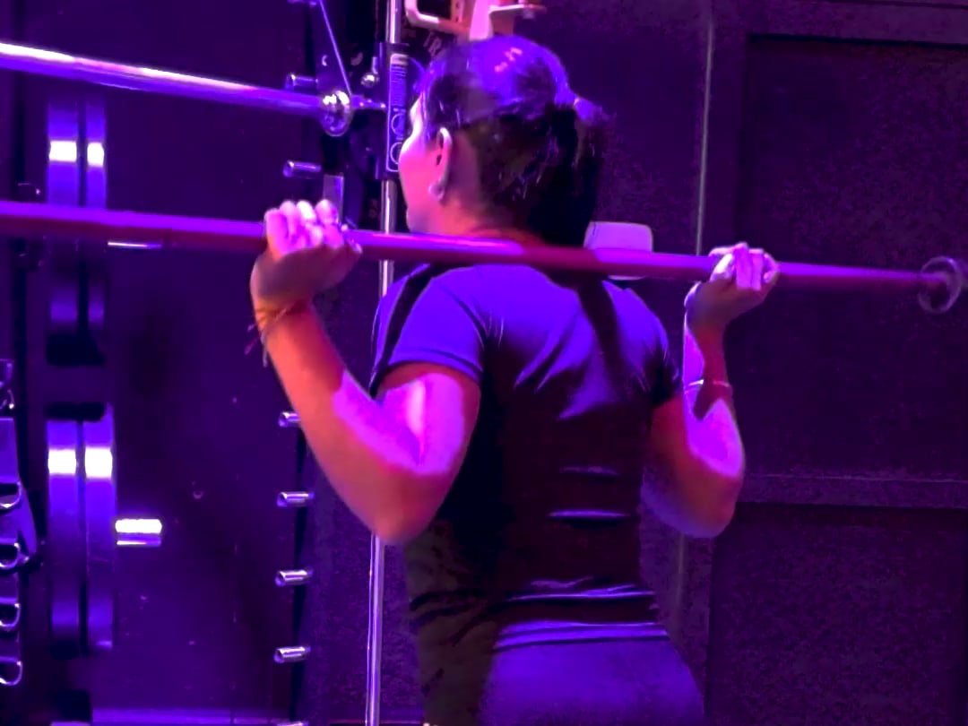 Alumna preparando una sentadilla con barra en el rack